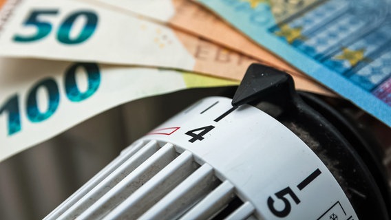 Eine Heizung ist auf Stufe vier gestellt, oben drüber liegen Geldscheine in der Währung Euro. © picture alliance / Zoonar Foto: stockfotos-mg