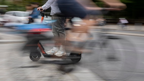Ein Mann kreuzt mit einem E-Tretroller einen Fahrradfahrer. © picture alliance/dpa Foto: Christoph Soeder