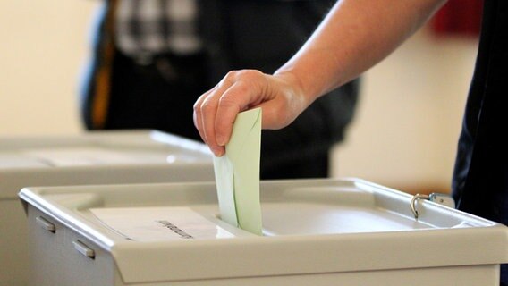 Jemand wirft einen Zettel in eine Wahlurne.  Foto: EIBNER/Daniel Fleig