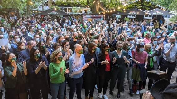 Menschen stehen auf der Wahlparty der Grünen vor einer Leinwand © NDR Foto: Peter Feder