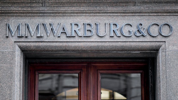 Das Logo des Bankhauses M.M.Warburg & CO ist in großen Lettern über dem Haupteingang in Hamburg befestigt. © dpa 