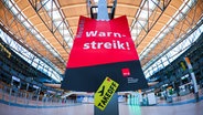 Ein Schild mit der Aufschrift "Warnstreik" hängt im Terminal 2 im Flughafen Hamburg. © picture alliance / dpa Foto: Christian Charisius