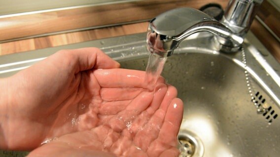 Eine Frau wäscht sich in einem Waschbecken unter einem Wasserhahn die Hände. © dpa Foto: Marcus Brandt