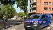 Mehrere Einsatzkräfte der Polizei stehen aufgrund eines Wasserrohrbruchs vor einem Gebäude. © HamburgNews 