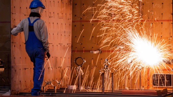 Ein Werftarbeiter überwacht Brennschnitt-Arbeiten an einem Schiffsmodul. © picture alliance/dpa 