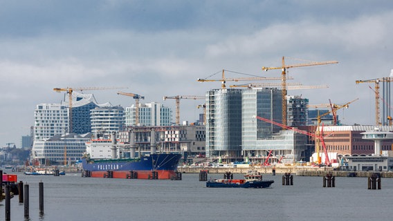 Kräne stehen auf der Groß-Baustelle des "Westfield Überseequartier". Tanker fahren vor der Baustelle auf der Elbe. © picture alliance/dpa Foto: Markus Scholz