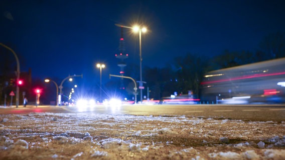 Autos fahren am frühen Morgen bei Schnee auf einer Hamburger Hauptverkehrsstraße. © dpa Foto: Christian Charisius