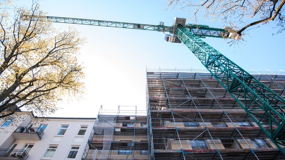 Ein Baukran steht neben einem Neubau mit Wohnungen in Hamburg. © picture alliance / dpa Foto: Daniel Bockwoldt