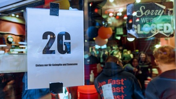 Im Fenster einer Hamburger Kiez-Kneipe hängt ein Zettel mit dem Text "2G, Einlass nur für Geimpfte und Genesene". © picture alliance/dpa Foto: Markus Scholz
