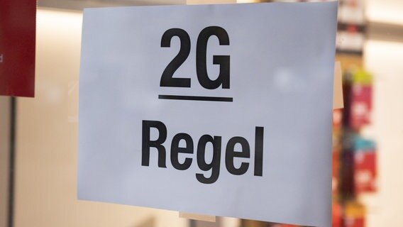 In einem Geschäft hängt ein Schild mit der Aufschrift "2G Regel". © picture alliance/dpa Foto: Christophe Gateau