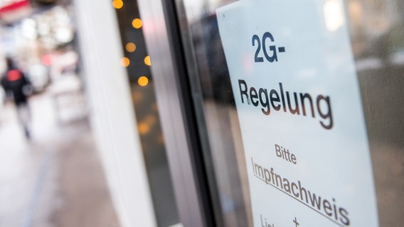 Ein Schild mit der Aufschrift "2G-Regelung. Bitte Impfnachweis" hängt am Fenster eines Lokals in Hamburg. © picture alliance / dpa Foto: Daniel Bockwoldt