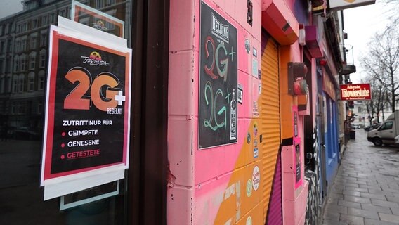 Ein Schild in einem Fenster einer Hamburger Kneipe weist auf die 2Plus-Regeln hin © dpa Foto: Marcus Brandt