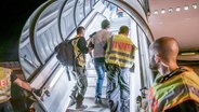 Polizisten führen im Jahr 2019 einen Afghanen in ein Flugzeug, um ihn in sein Herkunftsland abzuschieben. © Michael Kappeler/dpa Foto: Michael Kappeler/dpa