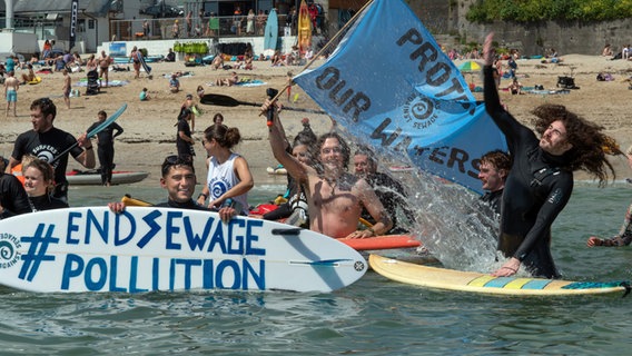 Die Gruppe "Surfers against Sewage" protestiert gegen die Einleitung von ungeklärtem Abwasser ins Meer im Vereinigten Königreich. © picture alliance / empics Foto: Emily Whitfield-Wicks