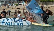 Die Gruppe "Surfers against Sewage" protestiert gegen die Einleitung von ungeklärtem Abwasser ins Meer im Vereinigten Königreich. © picture alliance / empics Foto: Emily Whitfield-Wicks