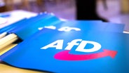 Fähnchen mit dem Logo der AfD liegen auf einem Tisch. © dpa bildfunk Foto: Daniel Karmann