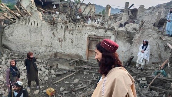 Auf diesem von der staatlichen Nachrichtenagentur Bakhtar veröffentlichten Foto betrachten Afghanen die Zerstörung durch ein Erdbeben in der ostafghanischen Provinz Paktika. © Uncredited/Bakhtar News Agency/AP/dpa 