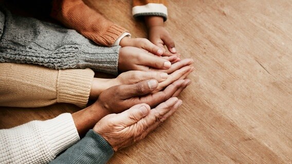Menschen unterschiedlichen Alters legen ihre Hände aneinander © Colourbox Foto: Peopleimages.com