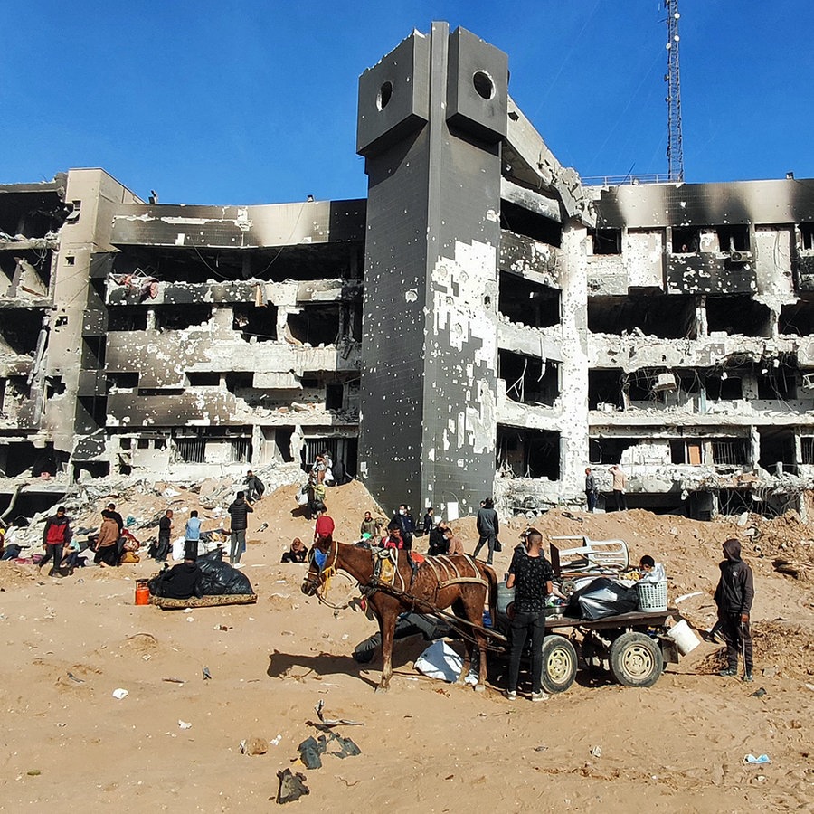 Menschen stehen vor dem stark beschädigten Schifa-Krankenhaus im Gazastreifen. © dpa-Bildfunk/APA Images via ZUMA Press Wire Foto: Khaled Daoud