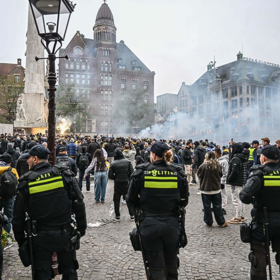 Sicherheitskräfte ergreifen Maßnahmen, während Fans von Maccabi Tel Aviv am Dam-Platz eine pro-israelische Demonstration veranstalten, bei der sie vor dem UEFA-Europa-League-Spiel zwischen Maccabi Tel Aviv und Ajax am 7. November 2024 in Amsterdam, Niederlande, Leuchtraketen zünden und Parolen rufen. © picture alliance / Anadolu | Mouneb Taim Foto: Mouneb Taim