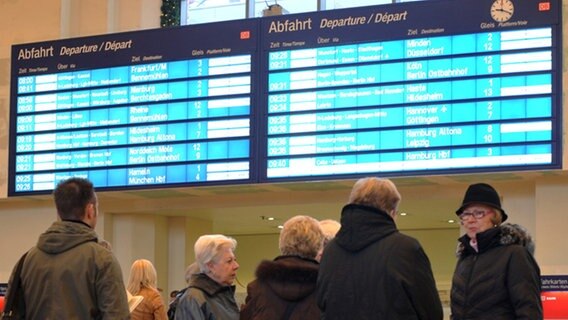 Reisende stehen vor der großen Anzeigentafel im Hauptbahnhof Hannover © dpa 