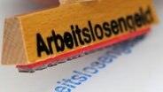 Ein Stempel mit dem Schriftzug "Arbeitslosengeld" © dpa - Bildfunk Foto: Oliver Berg