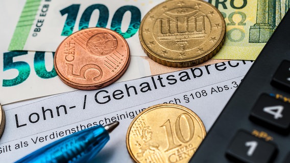 Eine Verdienstabrechnung, Cent-Münzen und Euro-Scheine liegen auf einem Tisch neben einem Stift und einem Taschenrechner. © picture alliance 