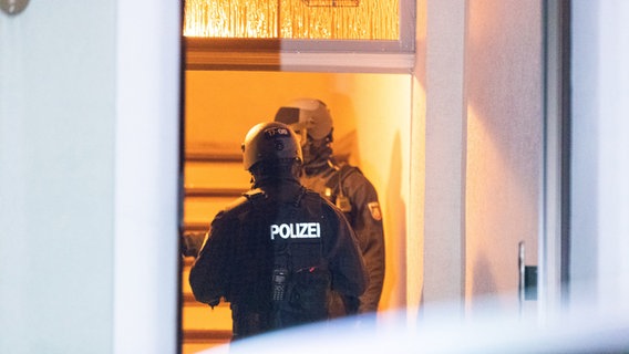 Ein Polizist trägt beim Einsatz einen hydraulischen Türöffner. © picture alliance/dpa Foto: Justin Brosch