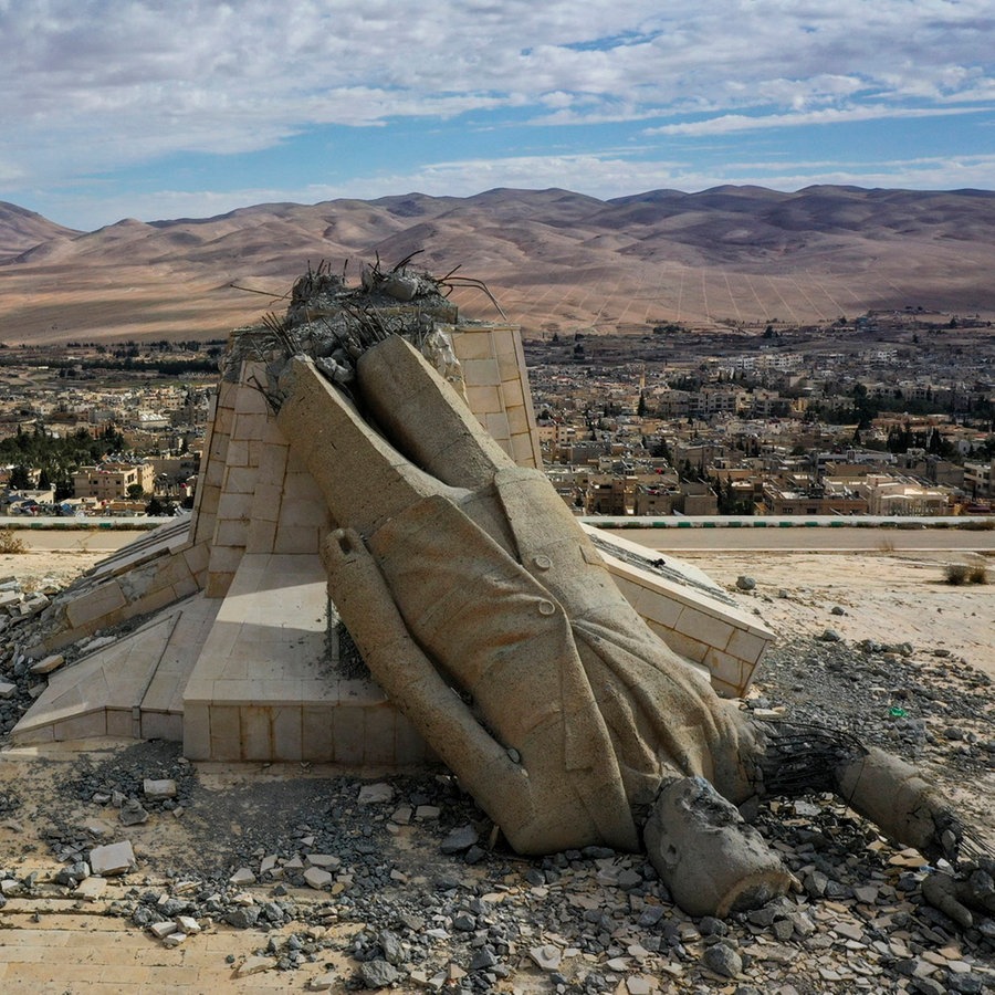 Syrien, Deir Atiyah: Eine Statue, die den verstorbenen syrischen Präsidenten Hafez Assad darstellt, und während des Aufstands, der das Assad-Regime im vergangenen Dezember stürzte, umgestürzt wurde, liegt in Trümmern auf einem Berg. © Ghaith Alsayed/AP/dpa 