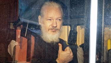 Wikileaks-Gründer Julian Assange sitzt in einem Polizeiauto und schaut aus dem Seitenfenster. © dpa picture alliance/ZUMA Press Foto: Rob Pinney