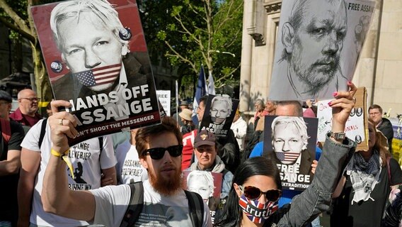 Unterstützer von Julian Assange halten vor einem Gerichtsgebäude in London Plakate in den Händen - auf einem steht "Hände weg von Assange". © dpa bildfunk/AP Foto: Kin Cheung