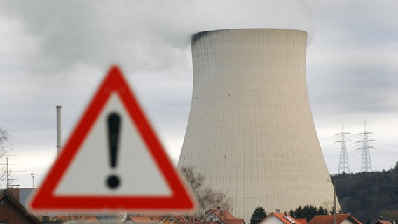 Isar I & Isar II: Ein Warnschild steht vor dem Kühlturm des Atomkraftwerks. © dpa Foto: Armin Weigel