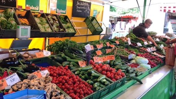 Junger Mann verkauft Gemüse auf einem Markt. © NDR Foto: Claudia Plaß