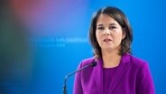 Bundesaußenministerin Annalena Baerbock (Grüne) steht bei einer Pressekonferenz in Lissabon auf einem Podium und spricht in ein Mikrofon. © dpa-Bildfunk Foto: Christophe Gateau