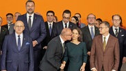 Die deutsche Außenministerin Annalena Baerbock bekommt von Gordan Grlic Radman, Außenminister von Kroatien, einen Kuss beim Gruppenbild bei der Europakonferenz zur EU-Erweiterung in Berlin. © Joerg Carstensen/dpa 