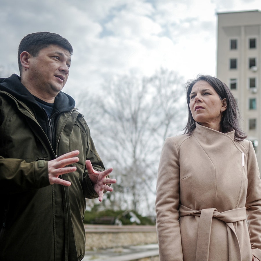 Außenministerin Annalena Baerbock (Grüne) und der Gouverneur der ukrainischen Oblast Mykolajiw, Witalij Kim, stehen vor dem zerstörten ehemaligen Sitz der Regionalverwaltung. © dpa Foto: Kay Nietfeld