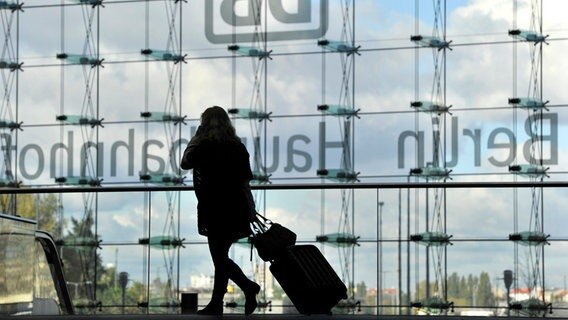 Eine Reisende zieht im Hauptbahnhof in Berlin ihren Koffer hinter sich her. © dpa Foto: Marius Becker