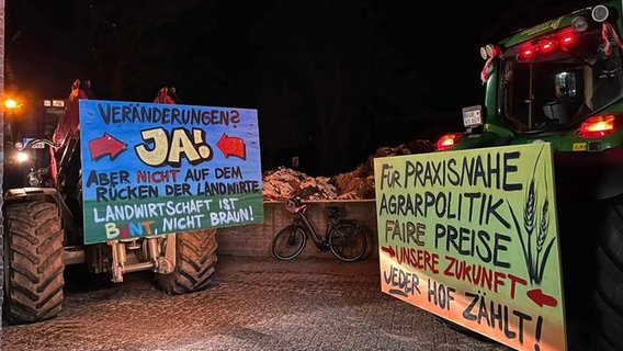 Zwei Traktoren mit Protestplakaten bei Nacht. © NDR Foto: Maren Osterbuar