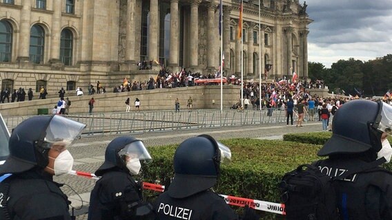 Teilnehmer einer Kundgebung gegen die Corona-Maßnahmen stehen vor dem Reichstag in Berlin. © dpa bildfunk Foto: Lukas Dubro