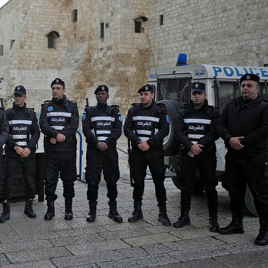 Palästinensische Polizisten stellen sich am Heiligabend in der Stadt Bethlehem im Westjordanland neben der Geburtskirche in Bethlehem auf. © dpa-Bildfunk/AP Foto: Matias Delacroix