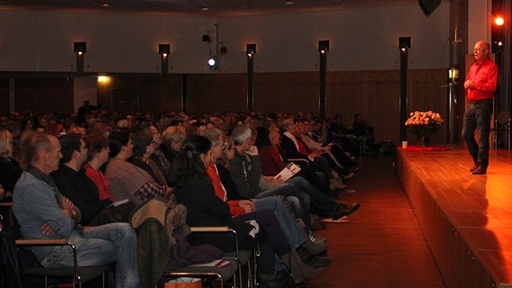 Robert Betz steht auf einer Bühne und hält einen Vortrag vor zahlreichen Zuschauern © NDR.de Foto: Kristina Festring-Hashem Zadeh