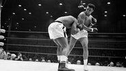 Cassius Clay (später Muhammad Ali) im WM-Kampf 1964 in Miami Beach gegen Titelverteidiger Sonny Liston (l.). © picture alliance / ASSOCIATED PRESS | Anonymous 
