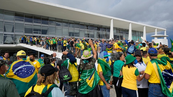Anhänger des ehemaligen brasilianischen Präsidenten Bolsonaro stürmen in Brasilia den Palacio do Planalto, den offiziellen Sitz des brasilianischen Präsidenten. © dpa bildfunk/AP Foto: Eraldo Peres