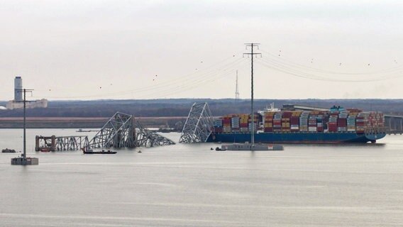 Das Containerschiff liegt unter der Francis Scott Key Bridge. ©  Steve Helber/AP/dpa 