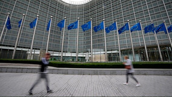 Belgien, Brüssel: EU-Fahnen flattern im Wind, während Fußgänger am EU-Hauptsitz vorbeigehen © AP/dpa Foto: Virginia Mayo