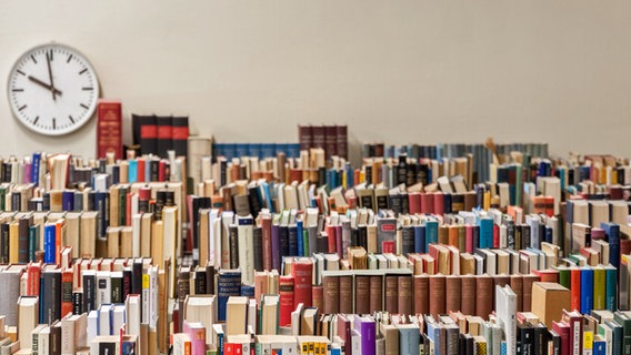 Blick auf mehrere Reihen mit Büchern in einer Bibliothek. © photocase 