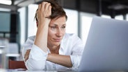 Eine Angestellte blickt frustriert in ihren Laptop. © picture alliance / Westend61 Foto: Rainer Berg