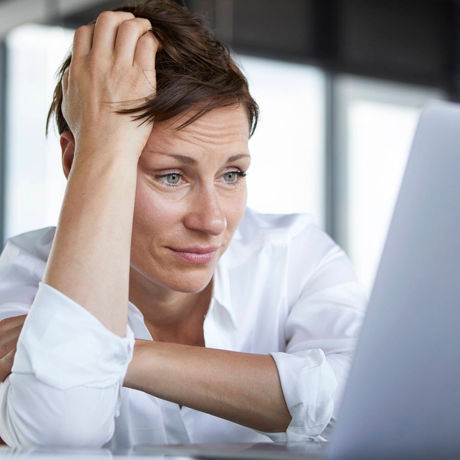 Eine Angestellte blickt frustriert in ihren Laptop. © picture alliance / Westend61 Foto: Rainer Berg