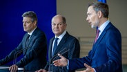 Bundeswirtschaftsminister Robert Habeck (Grüne), Bundeskanzler Olaf Scholz (SPD) und Bundesfinanzminister Christian Lindner (FDP) geben ein Pressestatement im Bundeskanzleramt. © Michael Kappeler/dpa 