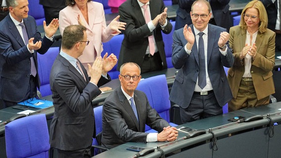 Alexander Dobrindt (CSU, 2. von rechts) und Jens Spahn (CDU, links) applaudieren dem neu gewählten Bundeskanzler Friedrich Merz (CDU, Mitte) bei der Kanzlerwahl im Bundestag. © dpa Foto: Michael Kappeler